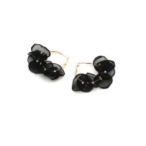 Dettaglio di cerchi dorati con petali di pizzo nero e piccole perline bianche decorative