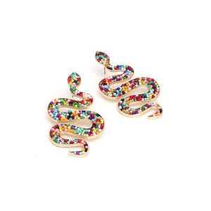Macro detail of gold snake earrings featuring colorful seed bead inlays in a retro style