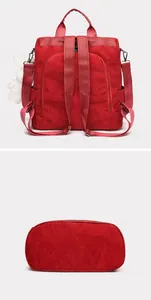 Detail view of red corduroy backpack showing anti-theft back pocket and oval base