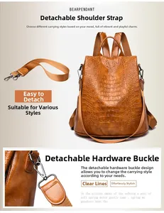 Detail of crocodile embossed brown backpack with detachable wide shoulder strap and metal hook