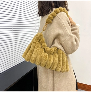 Close-up of brown plush shoulder bag featuring unique vertical pleated faux fur texture