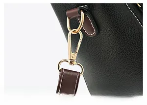 Détail du fermoir mousqueton doré de qualité et de la bandoulière en cuir noir