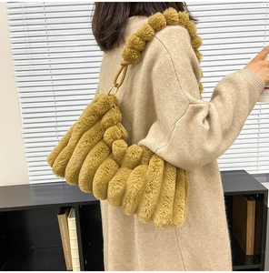 Detail of mustard yellow plush bag with vertical pleats and soft faux fur shoulder strap