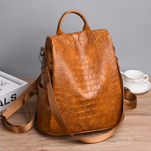 Macro view of brown crocodile-textured faux leather with anti-theft zipper detail