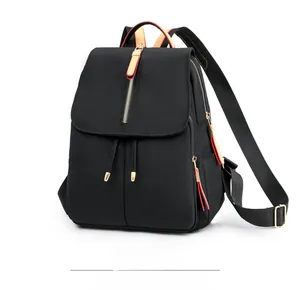 Detail of black waterproof nylon backpack with gold zippers and leather pullers