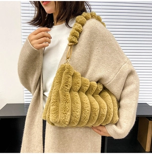 Detailed view of yellow plush shoulder bag with striped faux fur texture and metal link