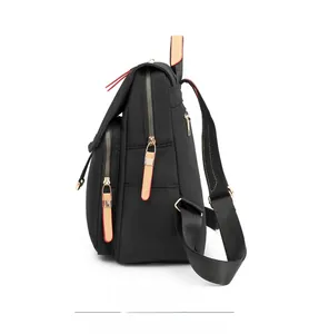 Side view of black water-resistant oxford backpack with multiple zippered pockets