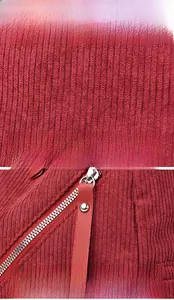 Detail of burgundy corduroy fabric with silver metal zipper and leather pullers