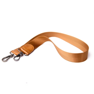 Close-up of brown woven bag strap with durable metal lobster clasps and leather ends