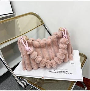 Detailed view of pink plush shoulder bag with vertical texture and fluffy strap detail