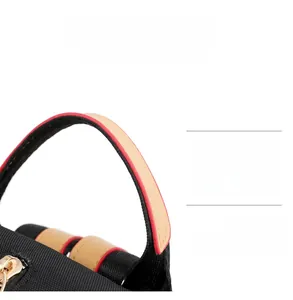 Detail of durable brown leather handle and gold zipper on black oxford backpack