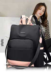 Détail du sac à dos en nylon bicolore noir et rose avec logo métallique et tissu durable