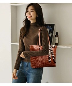 Detail of dark brown faux crocodile tote bag featuring a decorative leopard print scarf