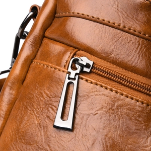 Close-up of vintage brown crocodile embossed leather with premium metal zipper detail
