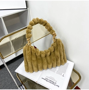 Detail of plush brown faux fur handbag with ribbed texture on art book background
