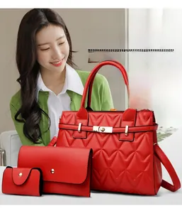 Detailed set of three red quilted leather bags with gold hardware held by a fashion model