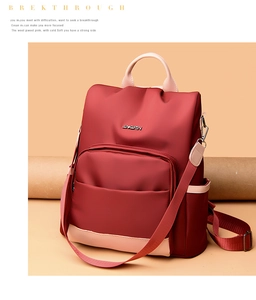 Détail du sac à dos en nylon bordeaux avec bretelles contrastées et logo en métal