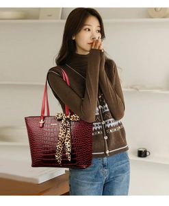 Detail of burgundy crocodile embossed tote bag with leopard silk scarf decoration