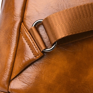 Detail of high-quality brown leather bag showing secure metal ring and stitching