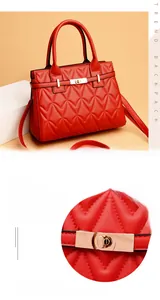 Detailed view of gold twist lock on red quilted shoulder bag with V-shaped stitching