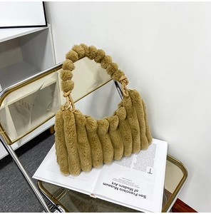 Detailed view of camel plush handbag with unique pom-pom handles and pleated faux fur