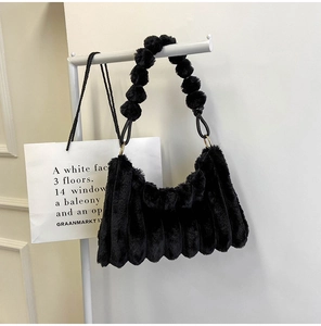 Detail of black plush bag featuring textured faux fur and unique bubble ball handle