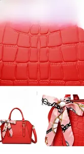 Macro detail of red crocodile embossed leather texture with silk scarf on handbag