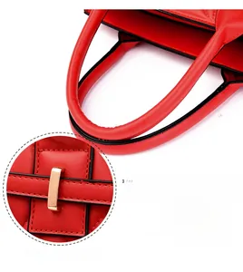 Detail of red quilted shoulder bag showing comfortable handle and golden metal hardware