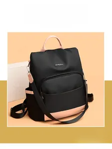 Détail du sac à dos en nylon imperméable avec accents en cuir rose et logo métallique