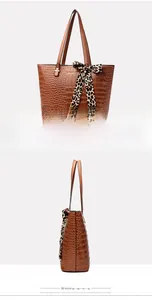Detail of brown embossed crocodile tote bag featuring a decorative leopard print silk scarf