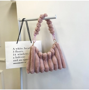 Detail of pink faux fur shoulder bag with soft pleats and gold metal ring hardware
