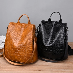 Detailed view of dual-color crocodile pattern PU leather backpacks in brown and black