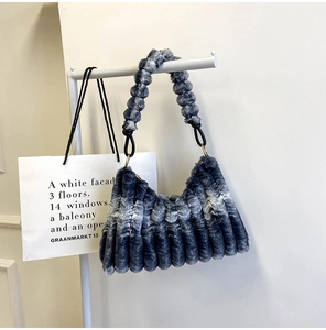 Detail of gray faux fur handbag featuring vertical pleats and gradient dye texture