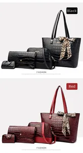 Close-up of crocodile embossed 4-piece handbag set in black and burgundy leather