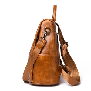 Detailed side view of brown faux crocodile leather backpack with adjustable nylon straps