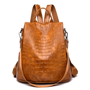 Detailed view of the brown crocodile texture and metallic zippers on the PU backpack