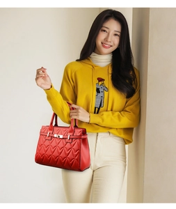 Close-up of red tote bag featuring heart-shaped quilting and a metallic buckle closure