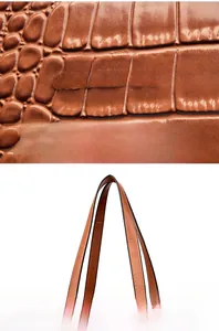 Close-up of brown crocodile embossed texture with golden JINGPIN logo and sturdy handles