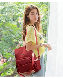 Détail du sac à dos en nylon rouge et rose avec poche frontale et rangement latéral