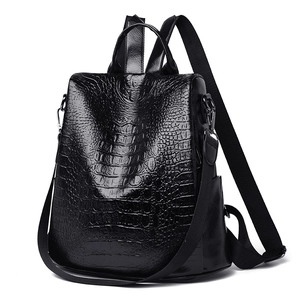 Detail shot of black crocodile embossed faux leather texture and gunmetal hardware