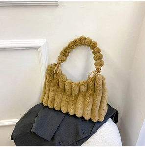 Detail of khaki plush handbag featuring vertical striped texture and soft fuzzy handles