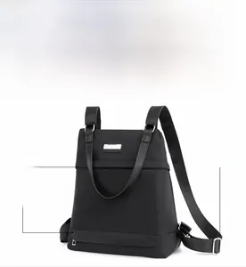 Close-up of black oxford backpack showing hidden zipper pocket and metal accent detail