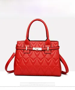 Detail of red quilted shoulder bag with gold twist lock and stitched chevron patterns