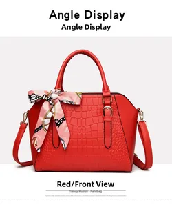 Front view of a red handbag featuring crocodile embossing and a decorative printed silk scarf