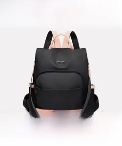 Vue avant du sac à dos en nylon noir avec détails roses et plaque logo métallique