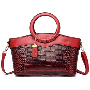 Sac à main rouge à motif crocodile avec poignées rondes et bandoulière amovible