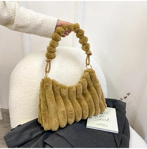 Detail view of brown plush tote bag with accordion folds and soft furry handle