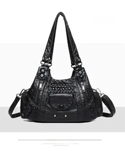 Detail of black vintage washed leather tote with multiple zipper pockets and studs
