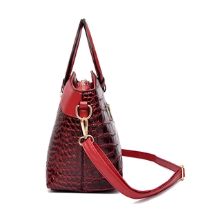 Sac à main élégant en cuir rouge avec motif crocodile et détails métalliques dorés