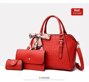 Three-piece red embossed bag set with shoulder bag, clutch, and purse in faux leather